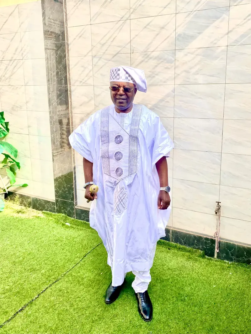 Adonsi Yaovi Mawuko Antoine, fondateur de l'auto-école Damaris, en tenue traditionnelle blanche
